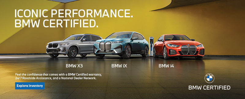 BMW Certified X3, iX, and i4 parked next to a colorful building wall.