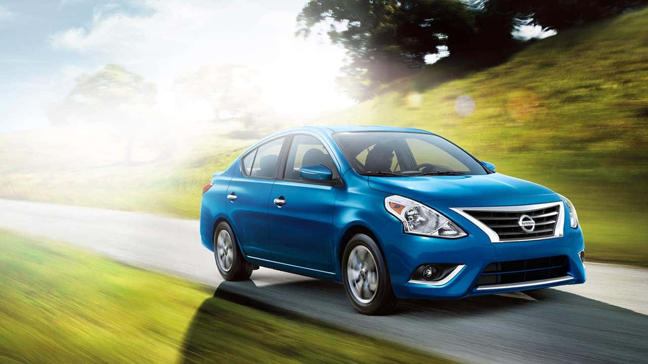 Blue 2017 Nissan Versa sedan driving on a country road