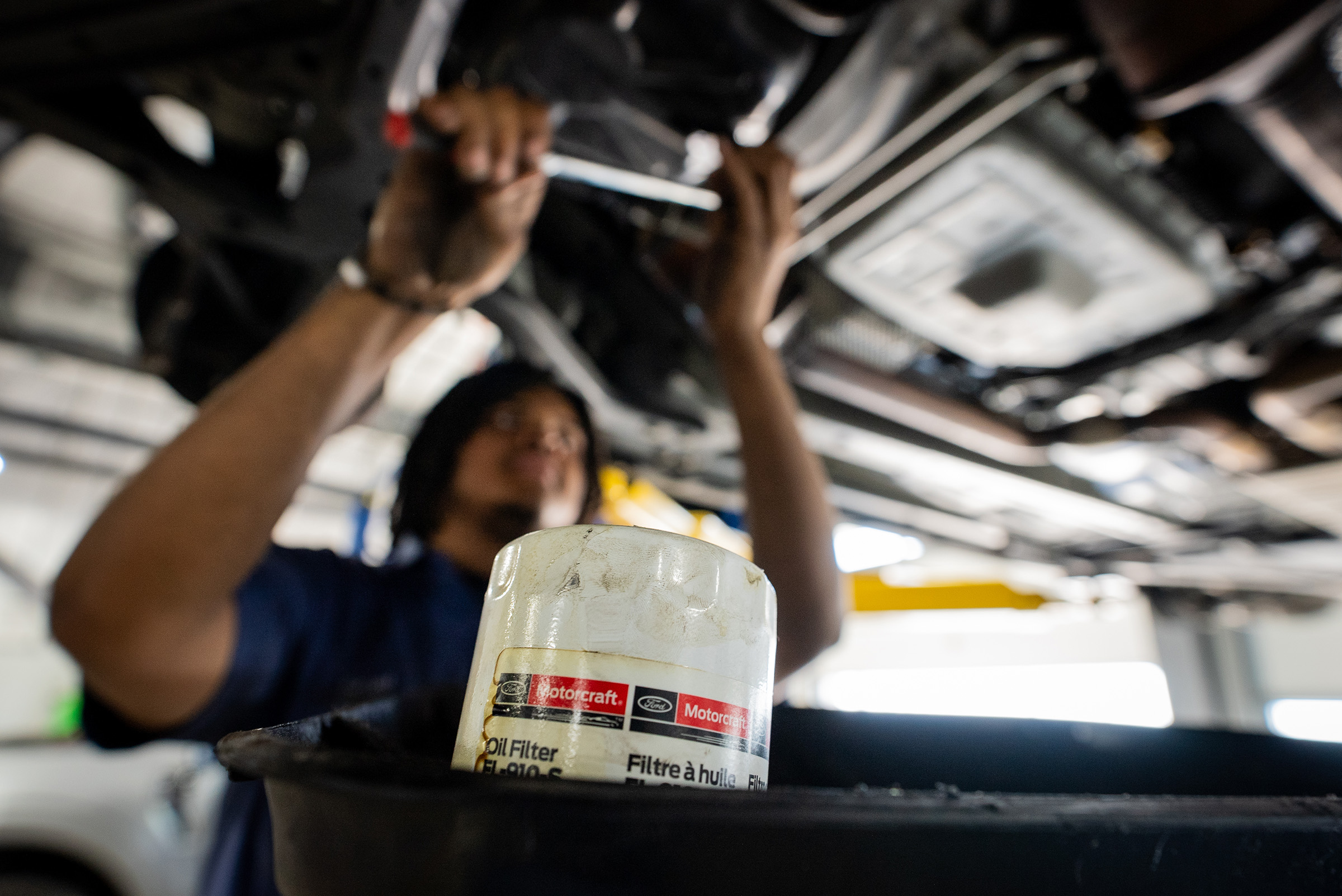Automotive technician at Don Hattan Ford of Augusta performing an oil change on a vehicle in his bay using Genuine OEM Motorcraft parts.