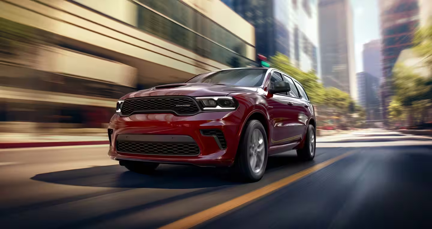 A red suv driving on the road.