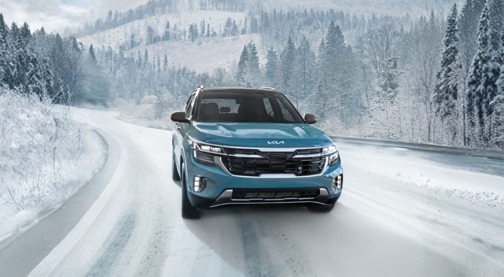 Blue 2026 Kia Seltos for sale driving on a snowy road