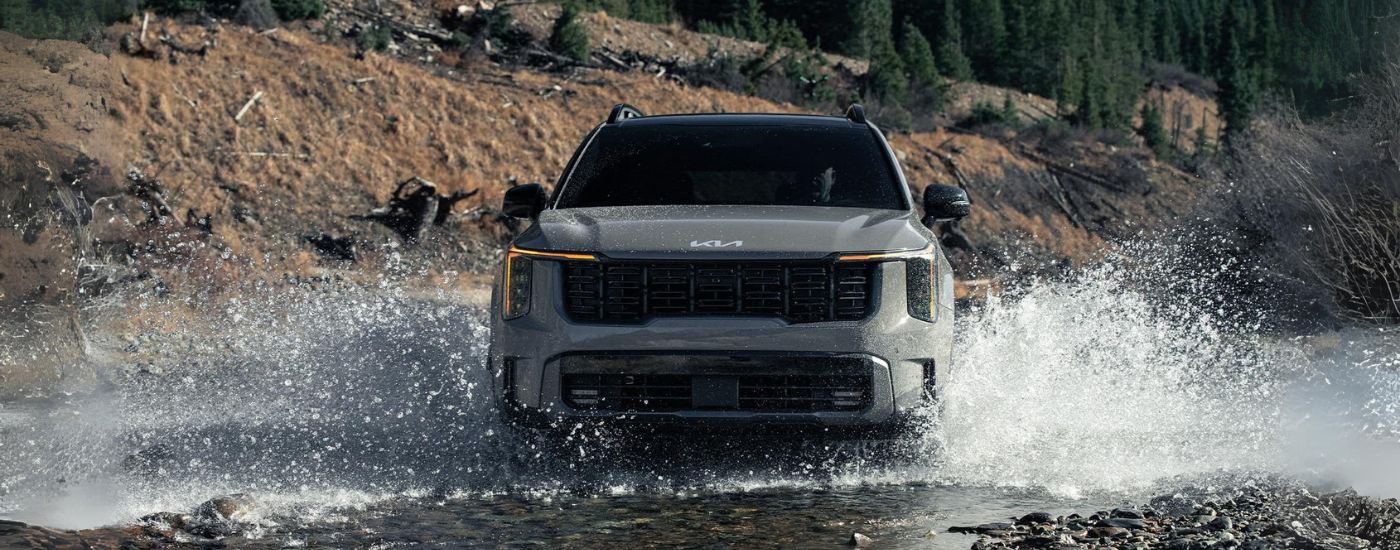 Grey 2026 Kia Sorento for sale near Edina driving over a shallow river