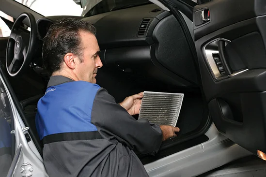 Technician inspecting Subaru brakes and fluids