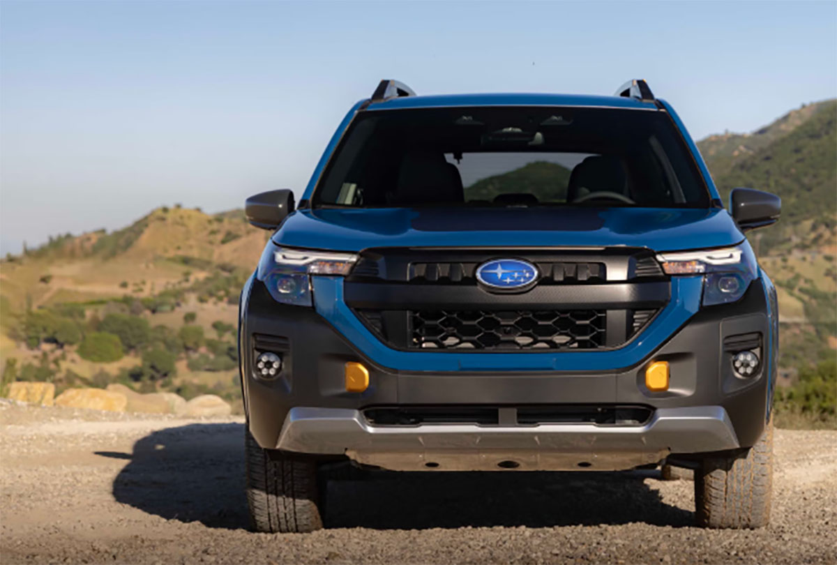 2027 Subaru Forester Wilderness Hybrid in blue, head-on front view on a gravel trail