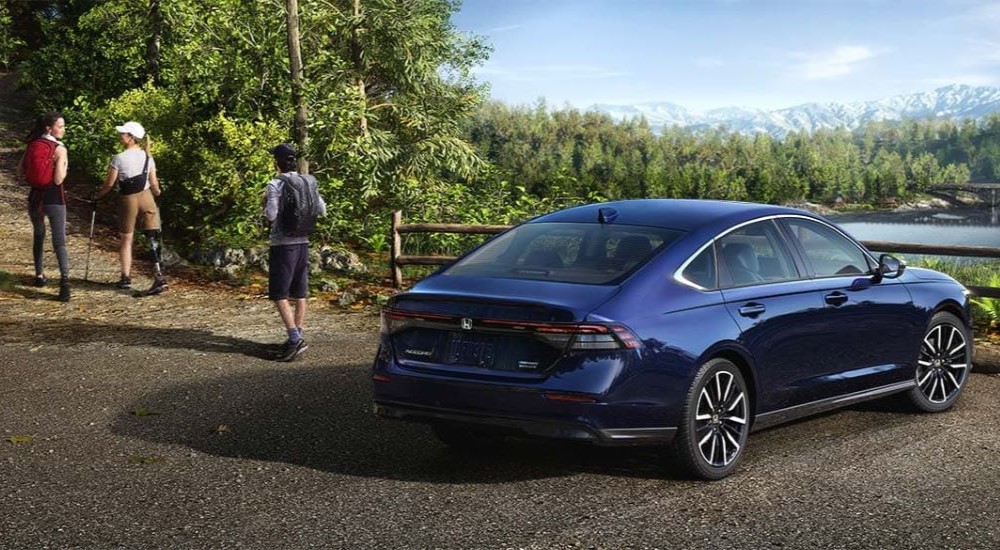 Hikers near a blue 2023 Honda Accord Hybrid for sale near Greece