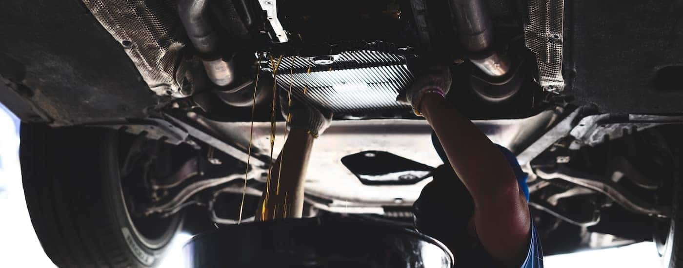 A mechanic performing a transmission fluid replacement.