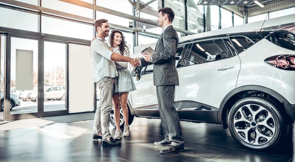 People talking to a car salesman.