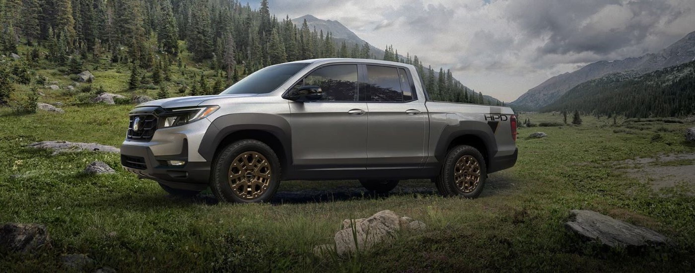 Silver 2023 Honda Ridgleine HPD is shown parked near mountains