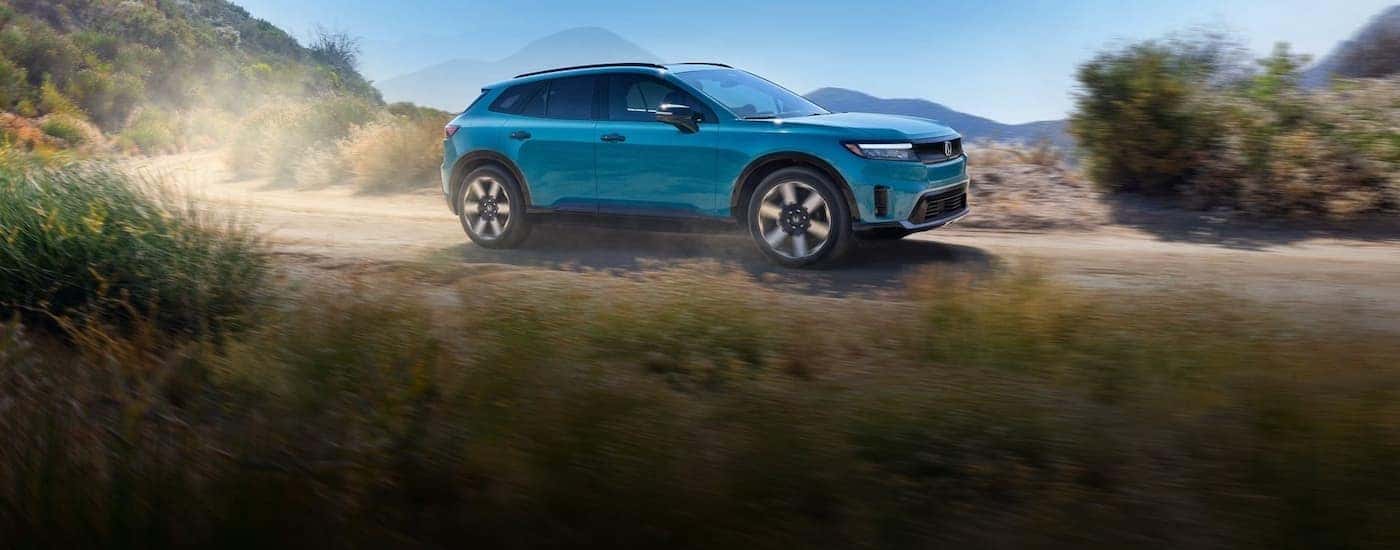 A blue 2024 Honda Prologue driving off-road.