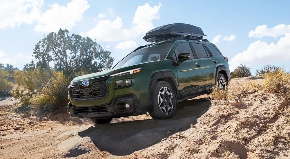 Green 2026 Subaru Outback Touring driving on a trail