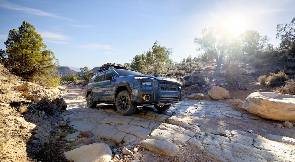 Dark blue 2026 Subaru Outback on a rocky path.