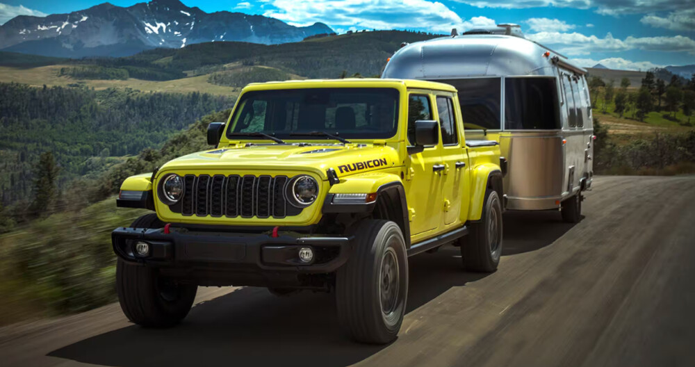 A Green 2024 Jeep Gladiator towing an RV