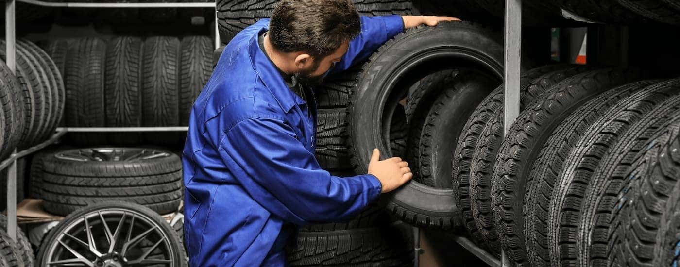 A mechanic is shown picking out tires for a customer.