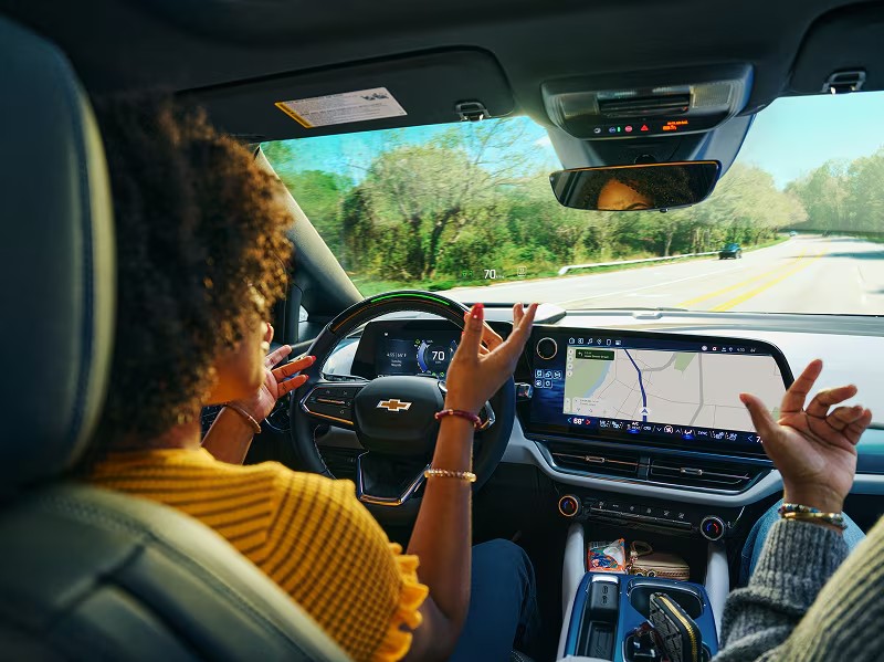 Chevy Super Cruise Being Used in Chevrolet Vehicle Interior Cabin Dashboard Driver Talking to Passenger