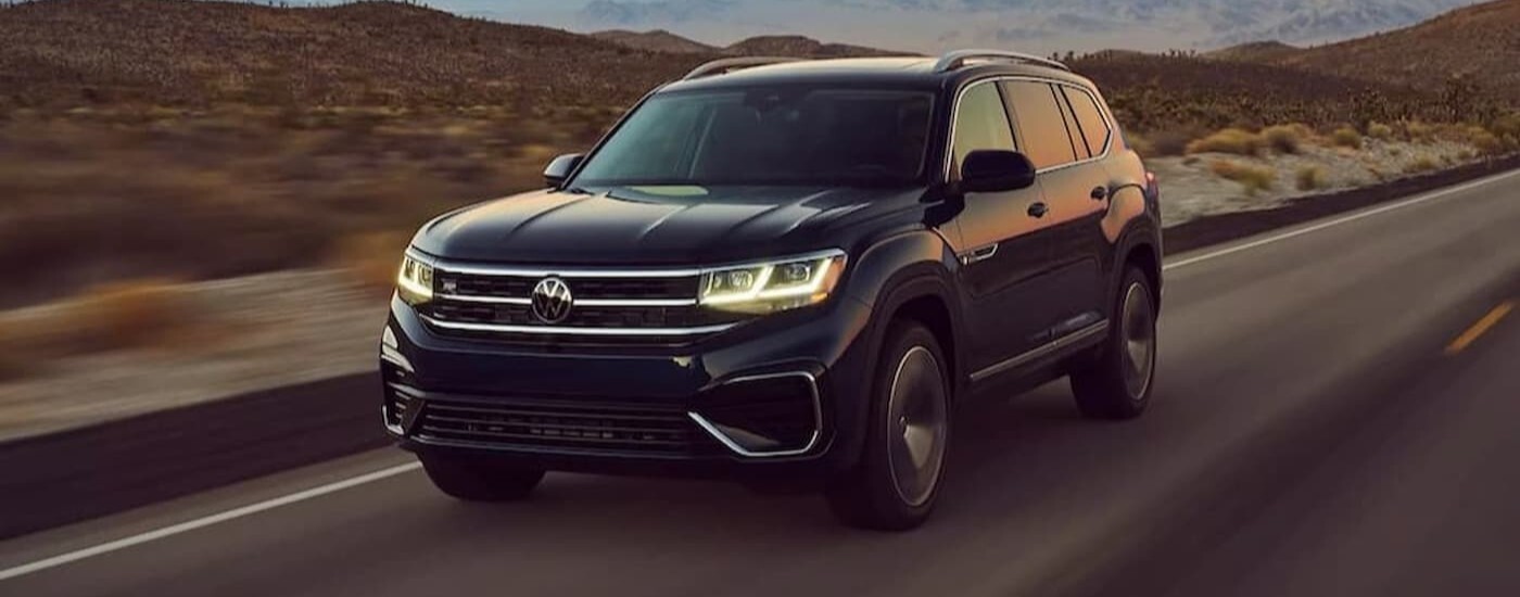 A black 2023 Volkswagen Atlas driving on a highway.