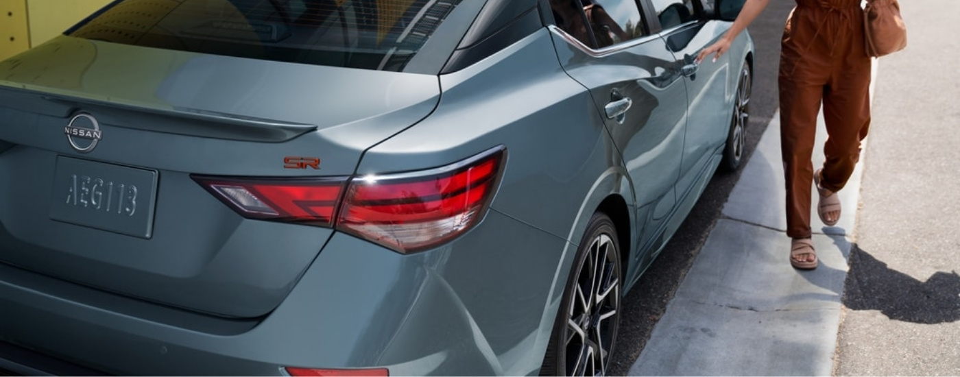 Persona abriendo la puerta de un Nissan Sentra SR 2024 gris