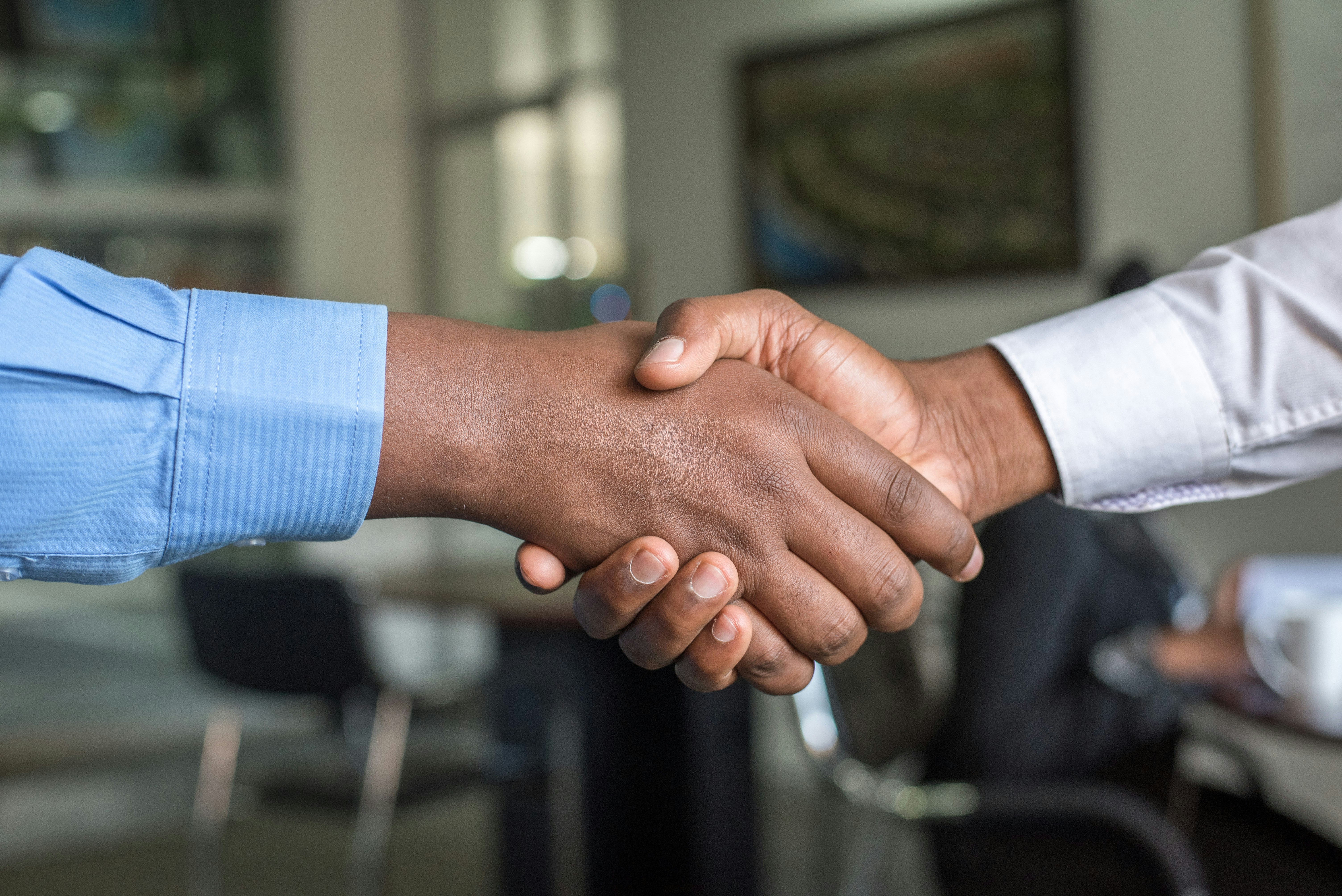 Customer and advisor shaking hands at dealership finance office