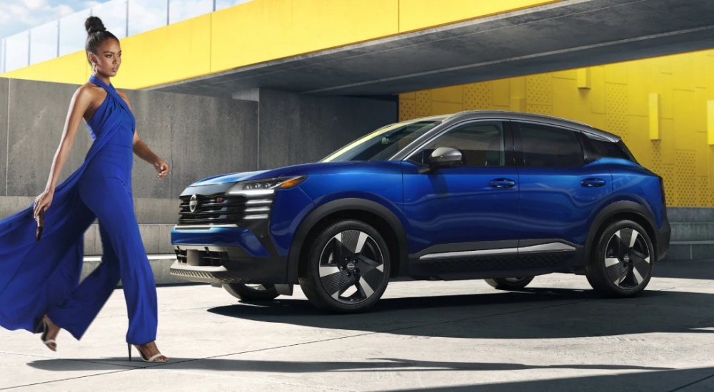 Person walking near a blue 2026 Nissan Kicks SR