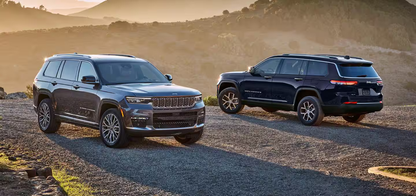 Two suvs sitting parked next to eachother.