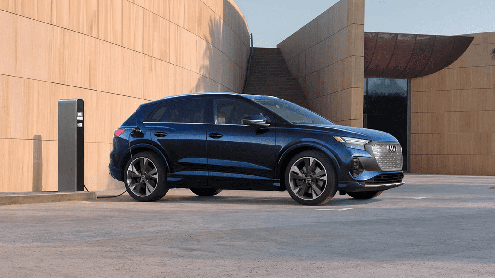 A blue Audi luxury electric SUV charging.