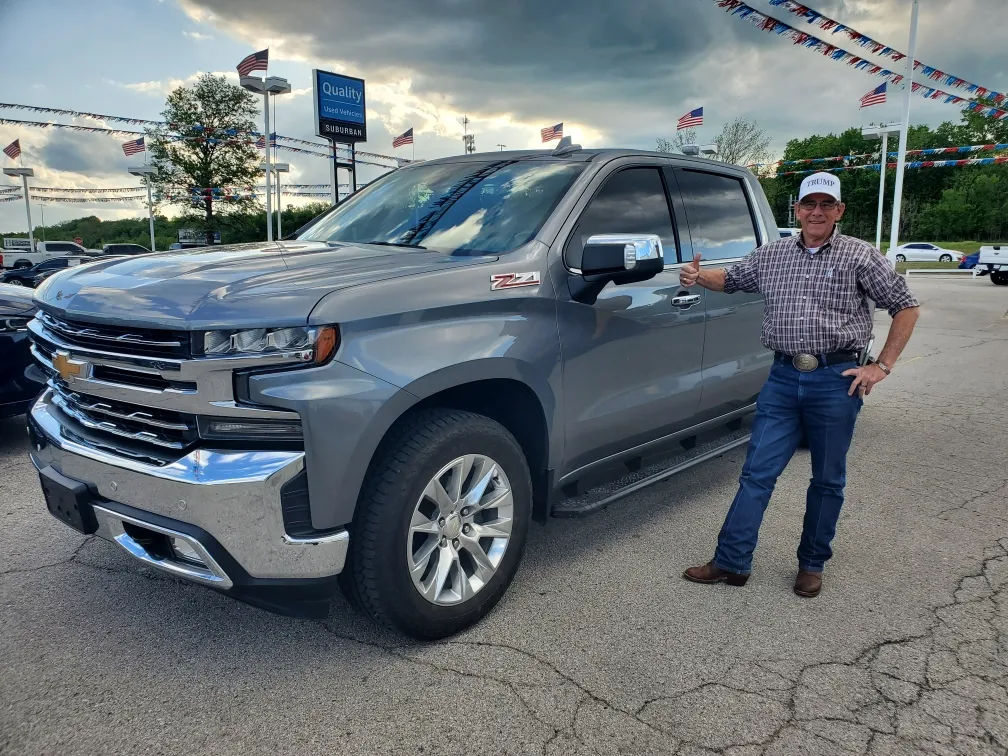 man smiling in front of a new chevrolet silverado 2500 hd in grey near Bixby, OK