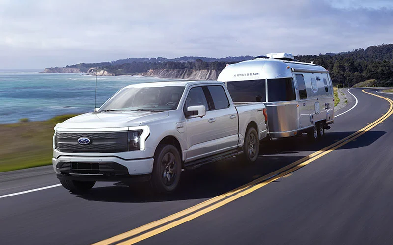 image of white ford f-150 towing camper