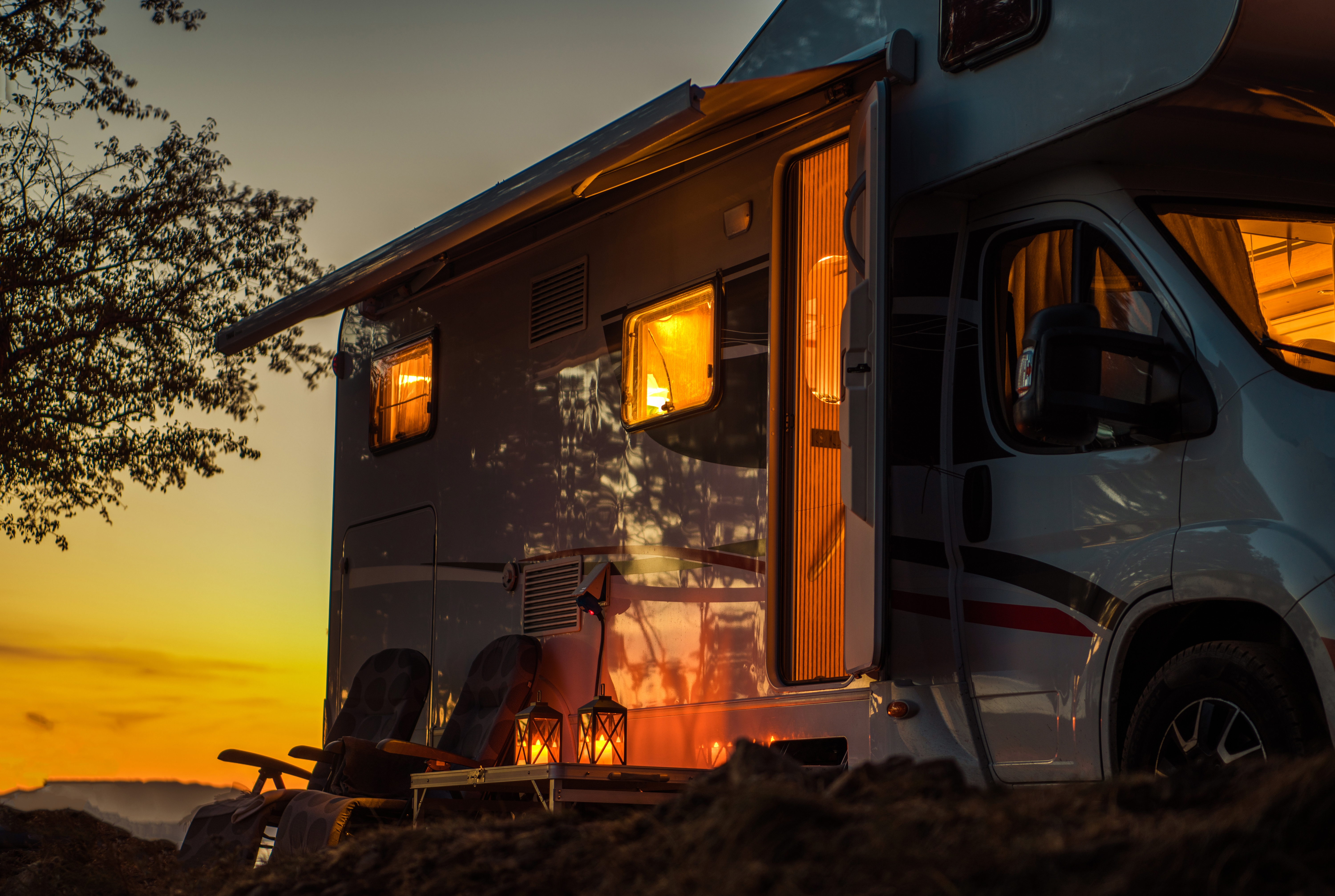 RV motorhome with its lights on and door open; pictured at dusk