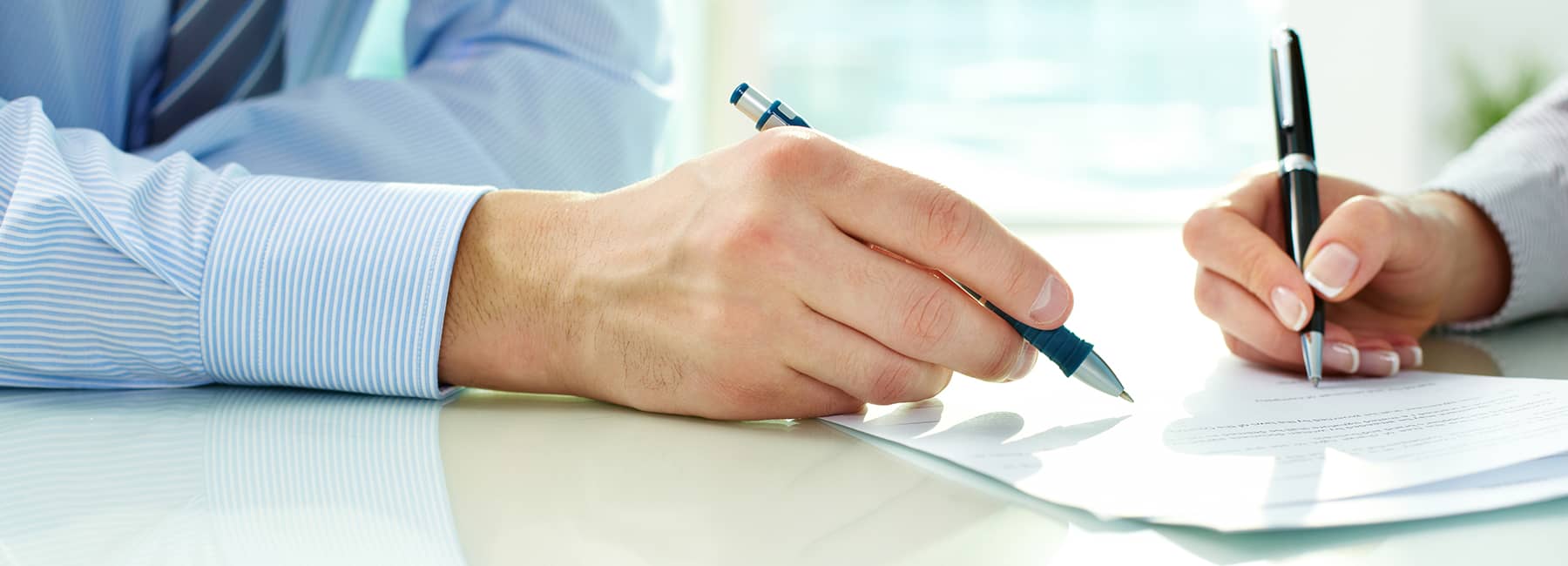 two-people-signing-paperwork