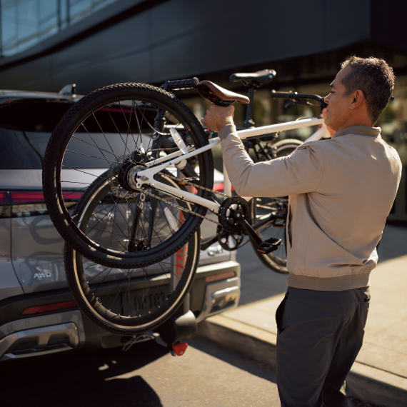 Man loading bike on INFINITI