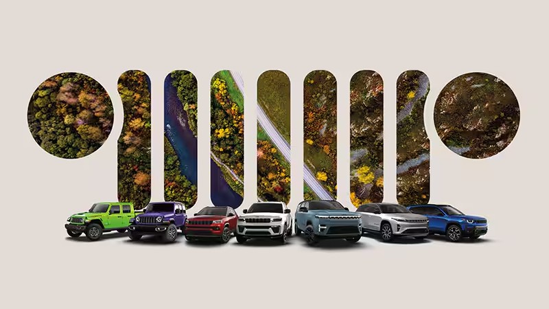 Jeep Lineup in Front of Jeep Grille Cutout of Scenery