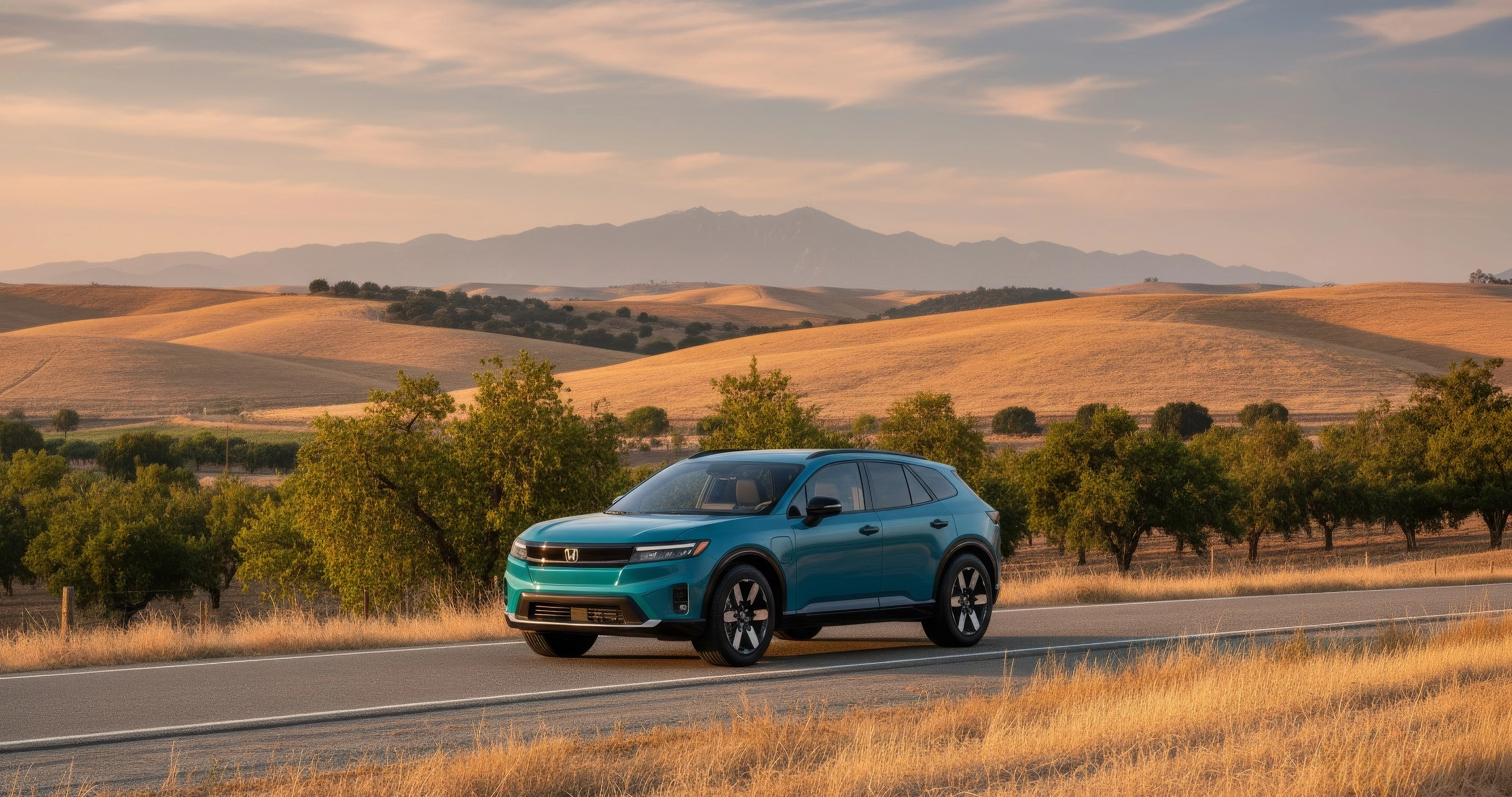 Teal Honda Prologue electric SUV driving along a scenic road through rolling golden hills at sunset