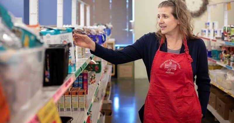 Volunteer in an apron at a school food pantry