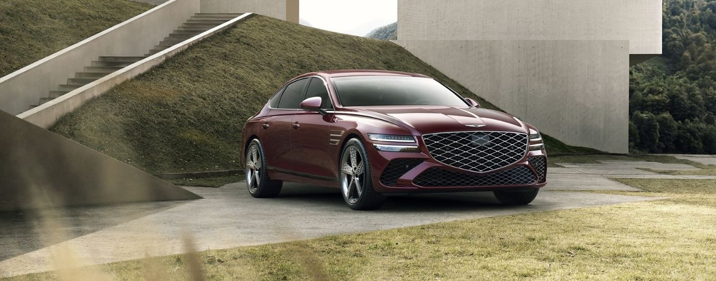 A maroon 2026 Genesis G80 parked by stairs.