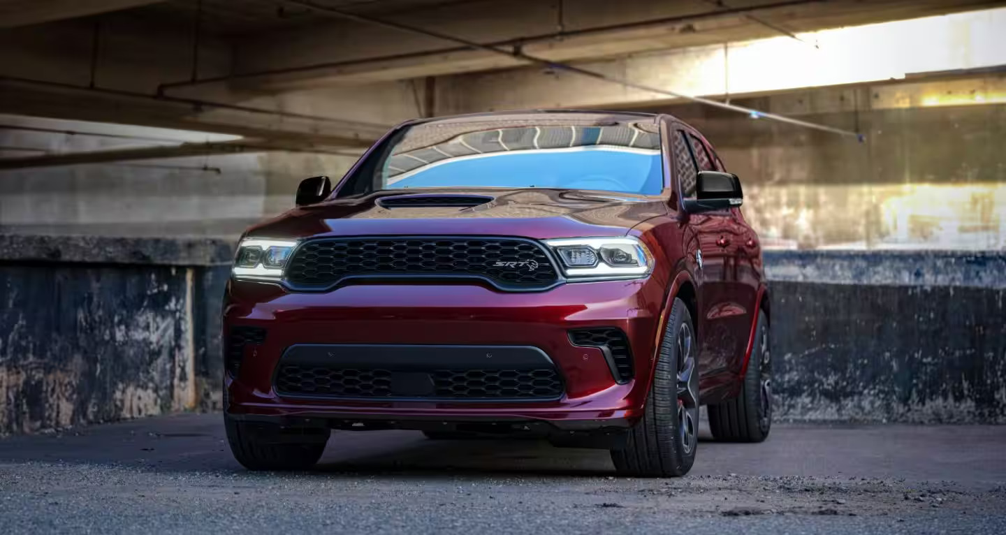 A red car sitting on a parking garage.