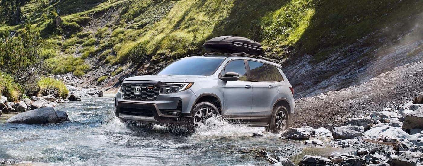 A grey 2023 Honda Passport is shown from the front at an angle.