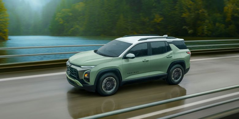 A green suv driving on the road.