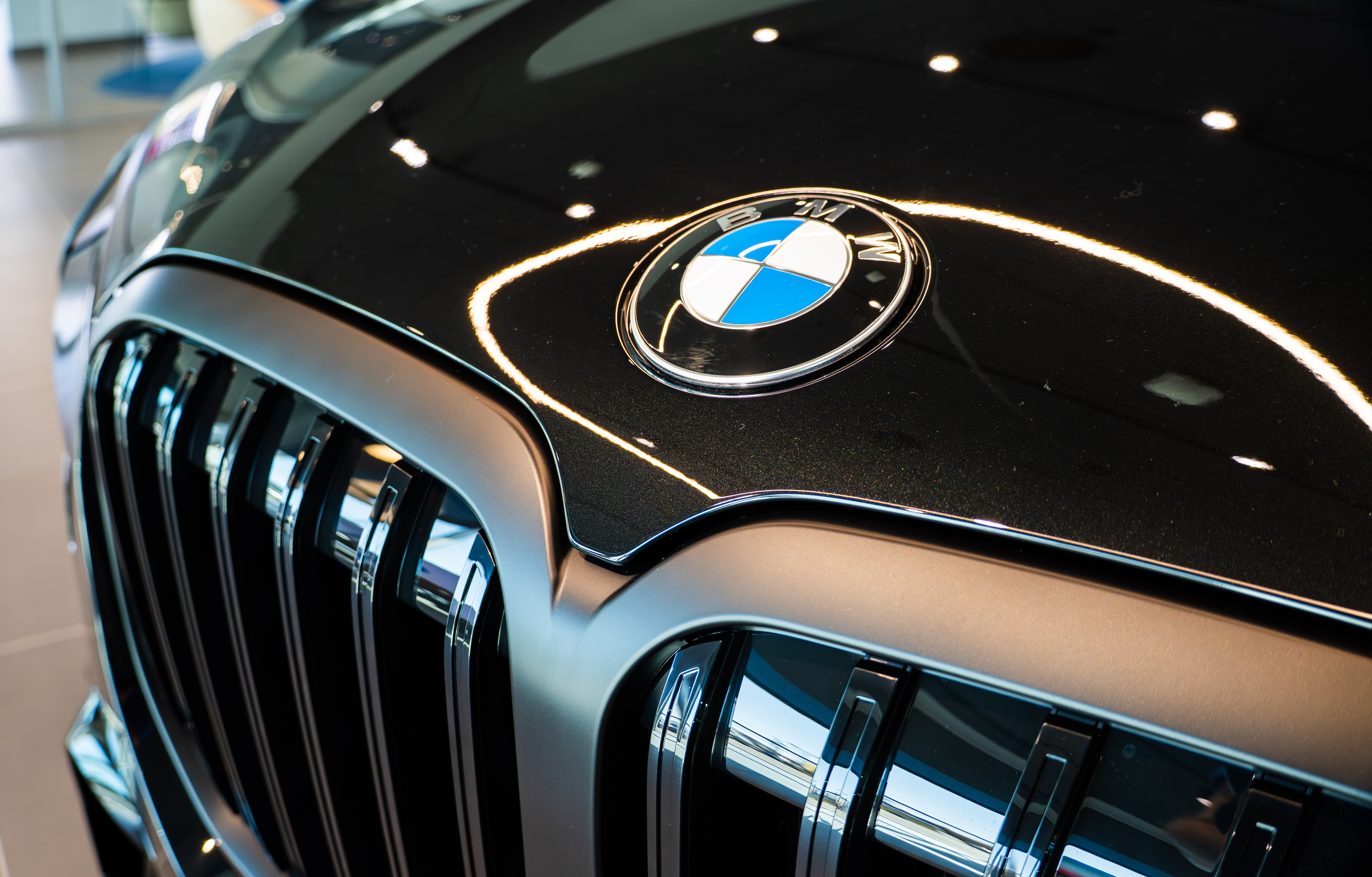 Close-up on a BMW car grille, focusing on the BMW logo.