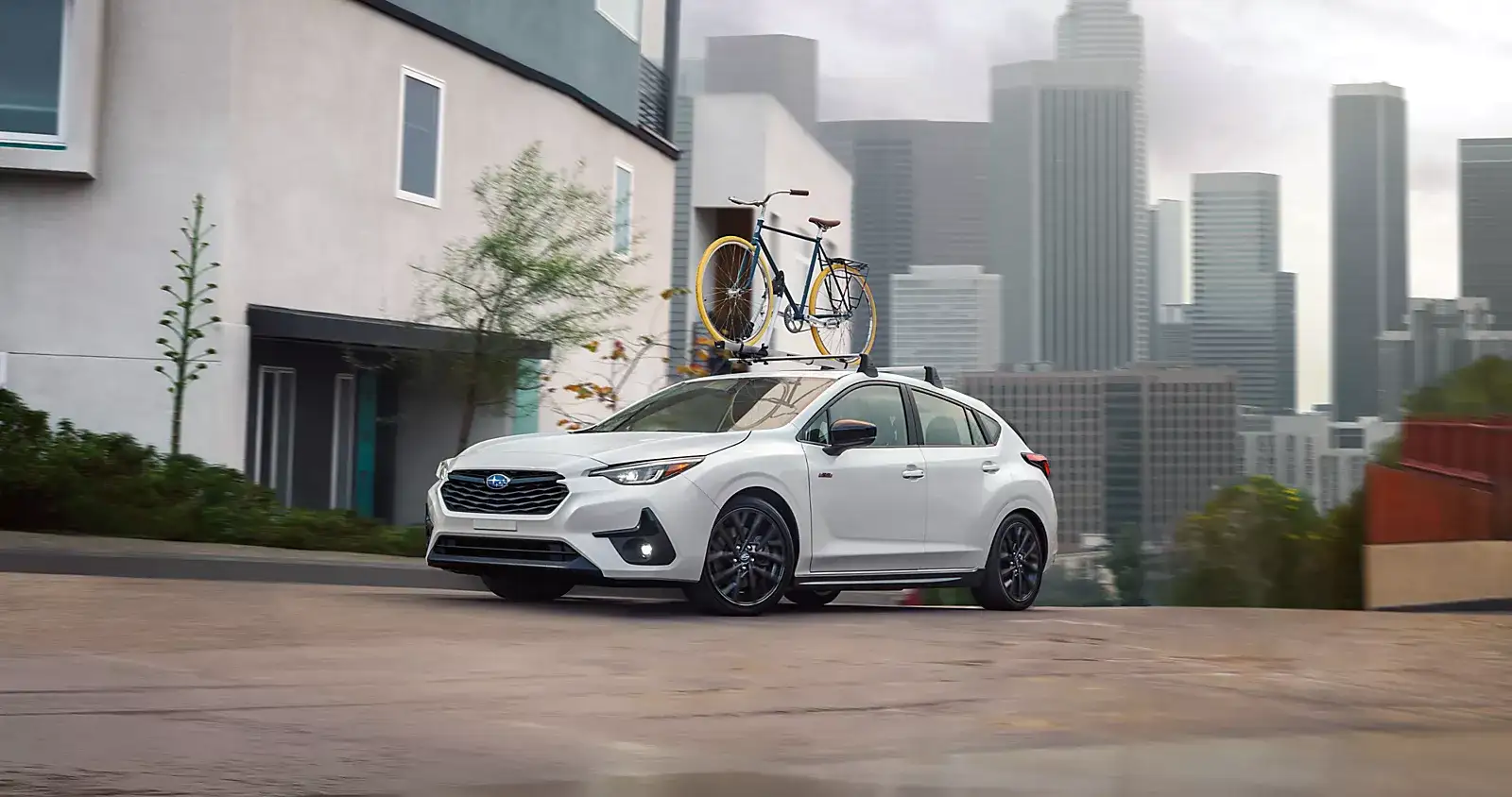 White Subaru Impreza with a roof bike rack in the city