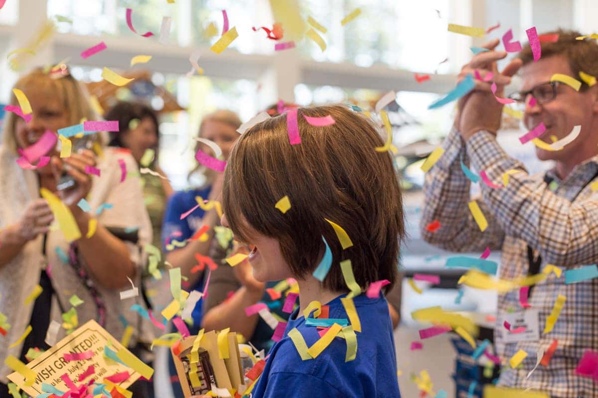 Danton celebrating under falling confetti at his Make-A-Wish reveal