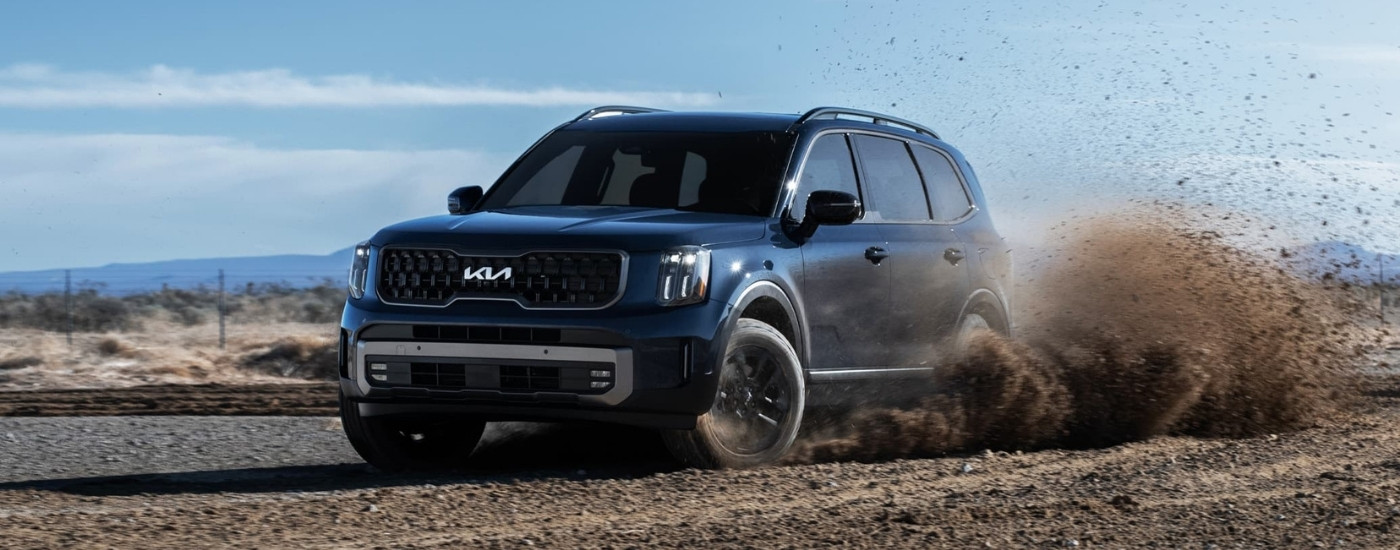 Blue 2025 Kia Telluride driving on a dirt track