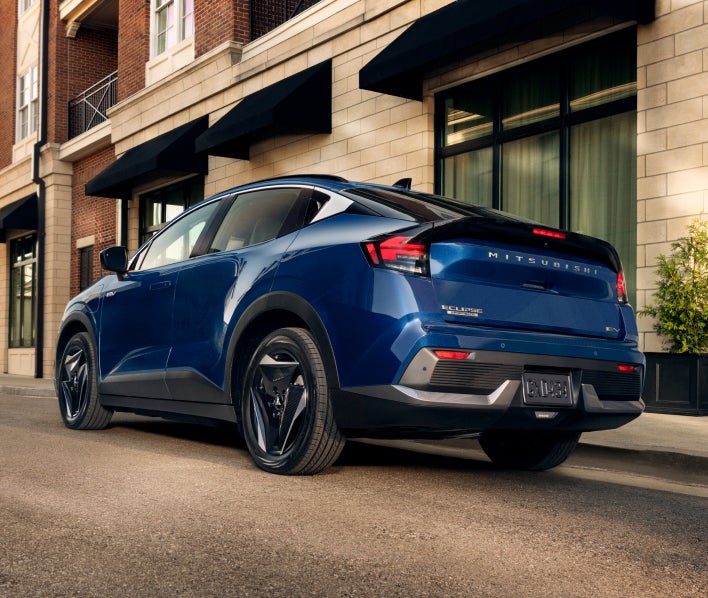 2027 Mitsubishi Eclipse Sportback EV in blue, rear three-quarter view on a city street