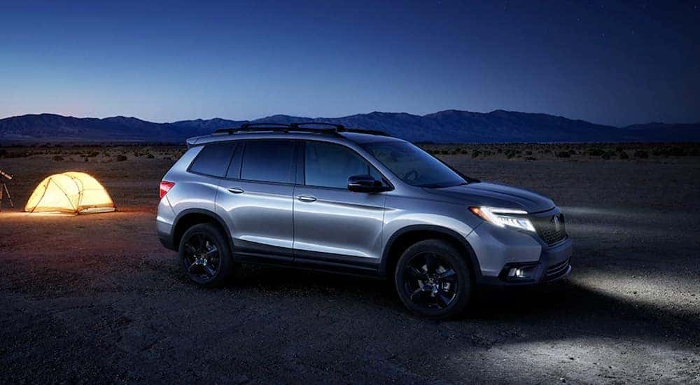 Silver 2020 Honda Passport Elite parked at a campsite at night