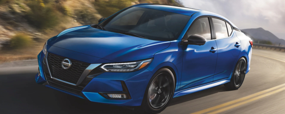 A blue 2022 Nissan Sentra driving on a winding road.