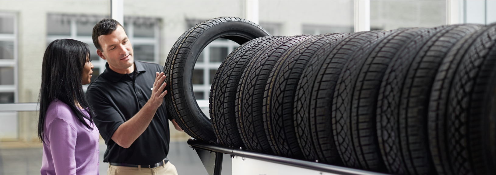 Subaru service representative showing customer a tire.