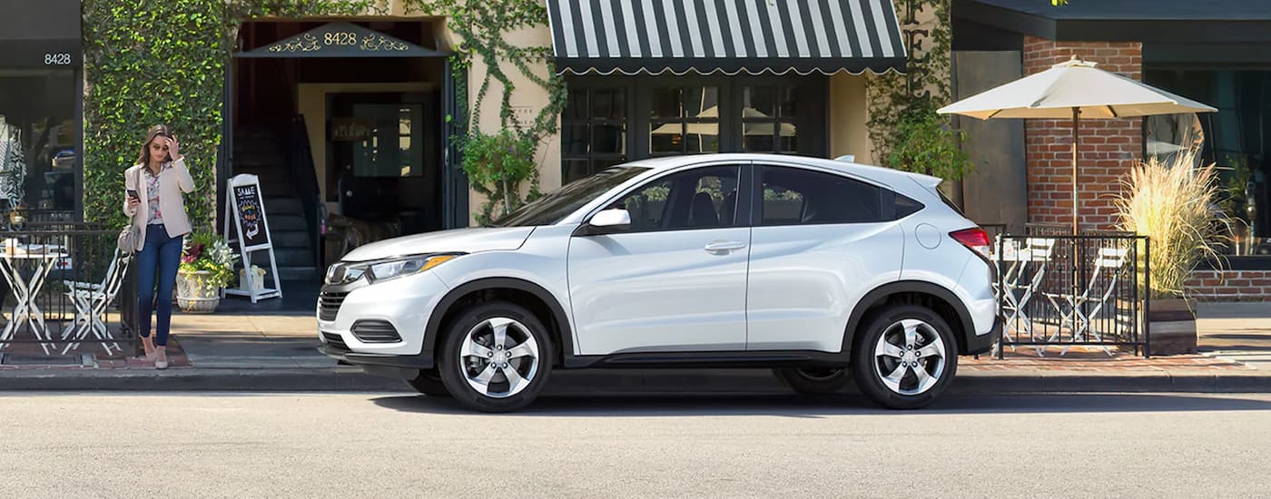 Side of a white 2020 Honda HR-V LX parked near a curb.