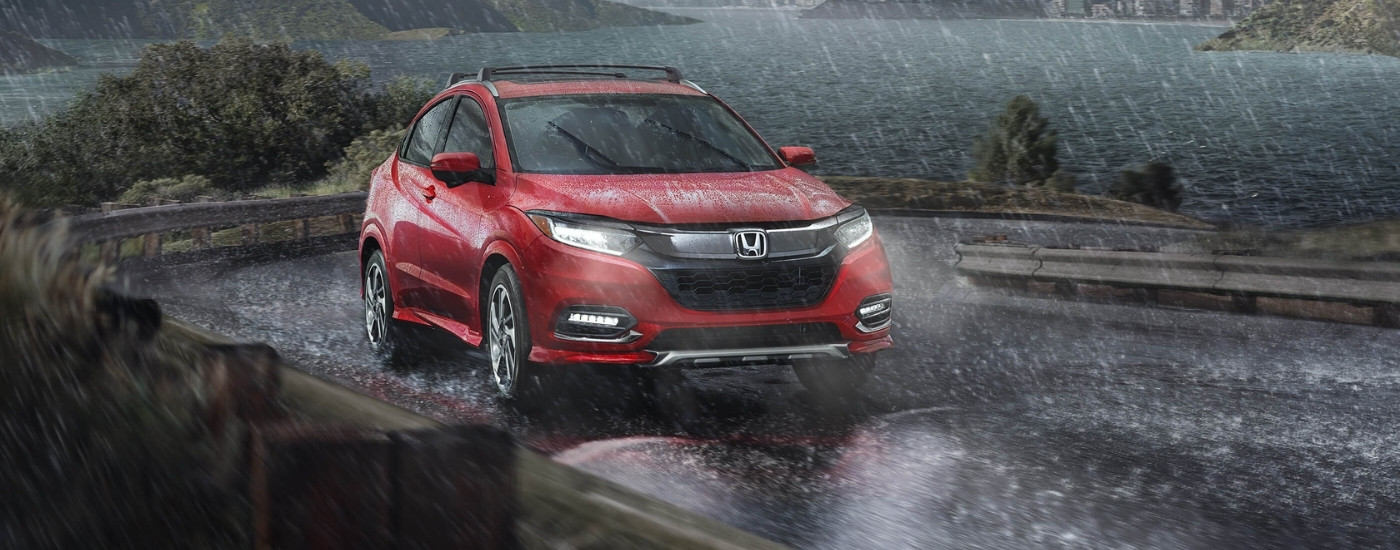 Red 2019 Honda HR-V driving on a wet road