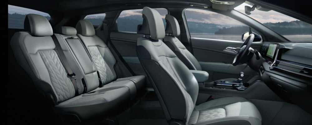 2025 Kia Sportage interior showcasing spacious seating, modern design, and advanced dashboard features, highlighting comfort and amenities for family travel.