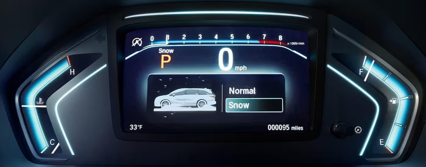 Close up shows gauge cluster and traction selection mode in a 2022 Honda Odyssey
