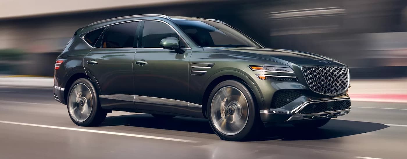 Side view of a 2025 Genesis GV80 for sale near Orlando driving on a highway