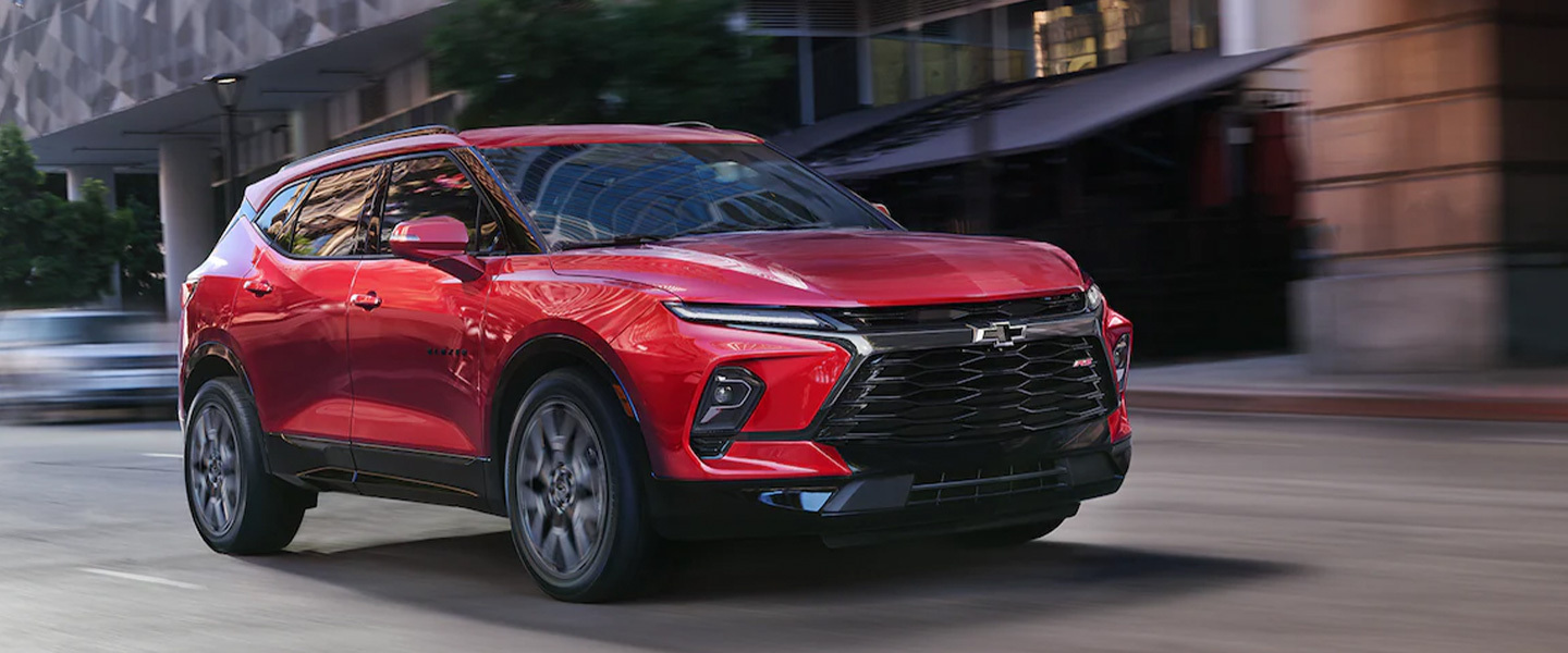 A red chevrolet blazer driving.